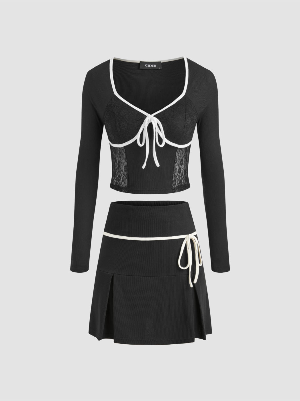 Top corsetto in pizzo con nodo a contrasto e gonna plissettata