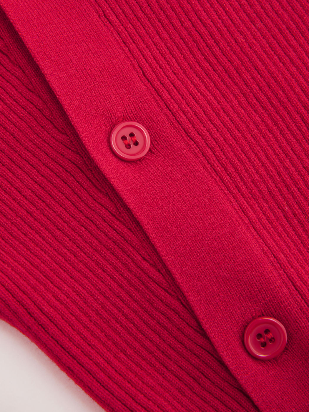 Top a maniche lunghe asimmetrico con bottoni in maglia