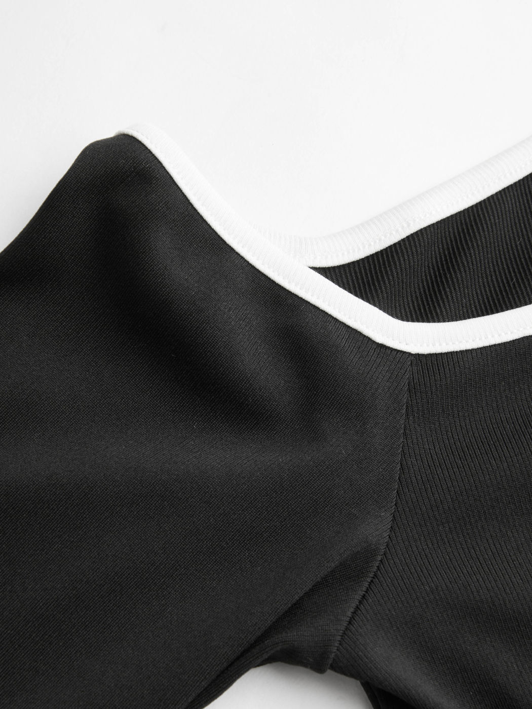 Top con scollo asimmetrico e rilegatura a contrasto