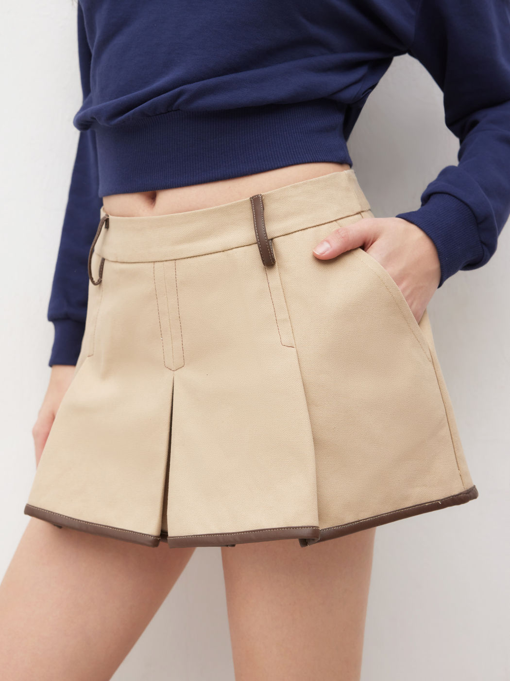 Minigonna a vita bassa con pieghe e bordi a contrasto