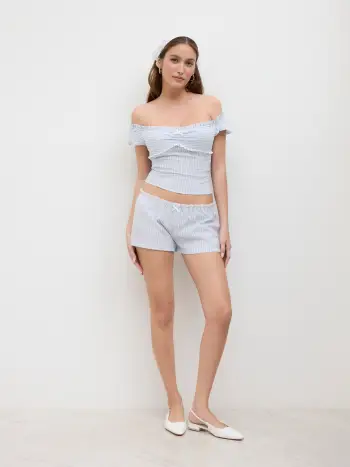 Completo composto da top a righe con fiocco in misto cotone e pantaloncini a vita media con rifiniture in pizzo inglese