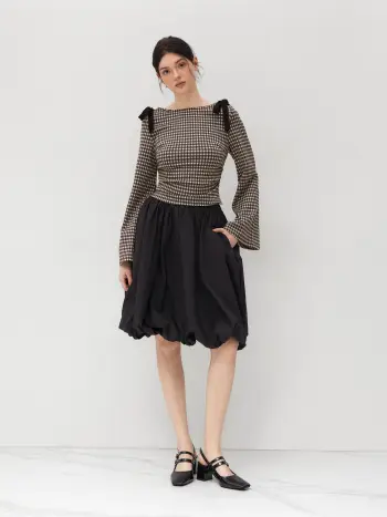 Top a maniche lunghe con scollo a barca e nodo a fiocco con increspature