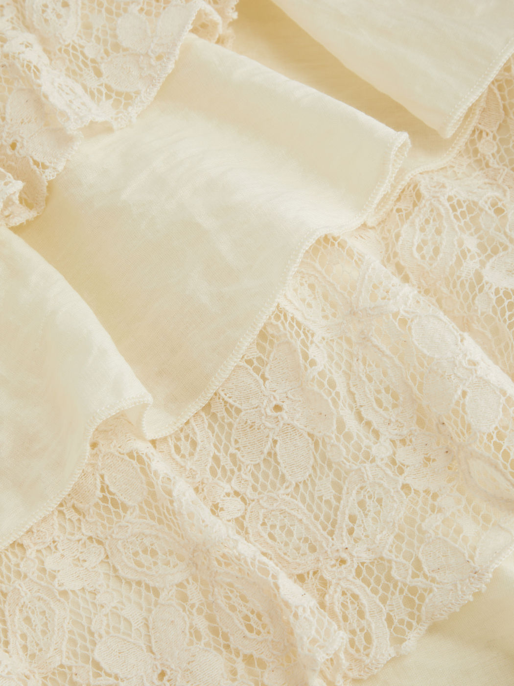 Top asimmetrico con collo in pizzo e balze a strati annodato in misto cotone