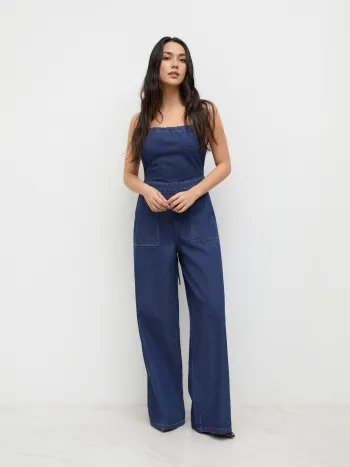 Tuta in denim con lacci sulla schiena, senza schienale e a gamba larga