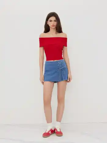 Mini gonna-pantalone a trapezio in denim stretch con spacco e fiocco a vita media