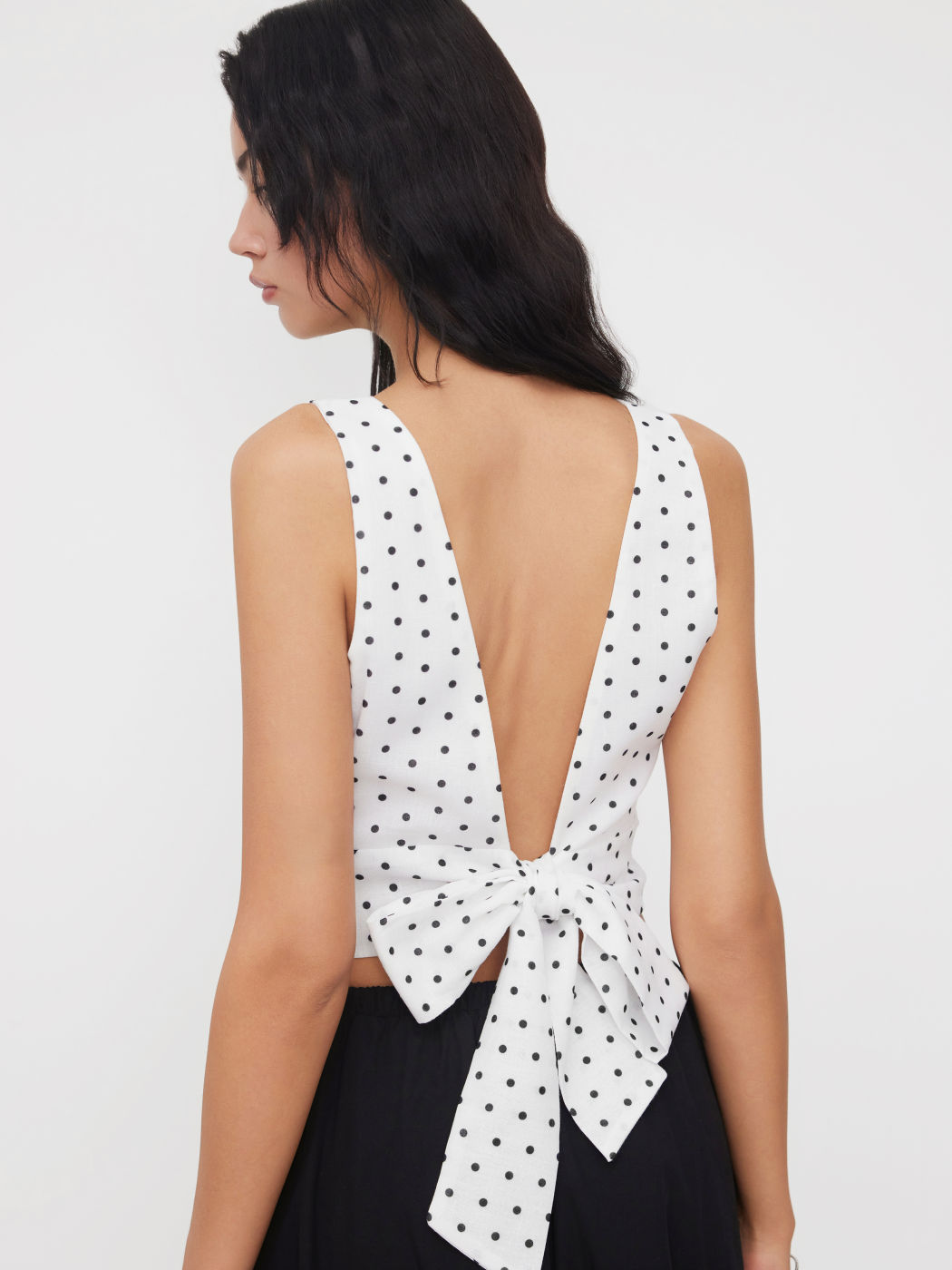 Top corto con scollo a barchetta, pois e fiocco senza schienale