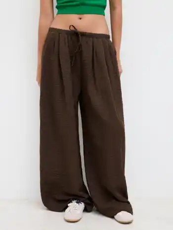 Tief sitzende Hose mit elastischem Bund und Knoten an weiten Beinen